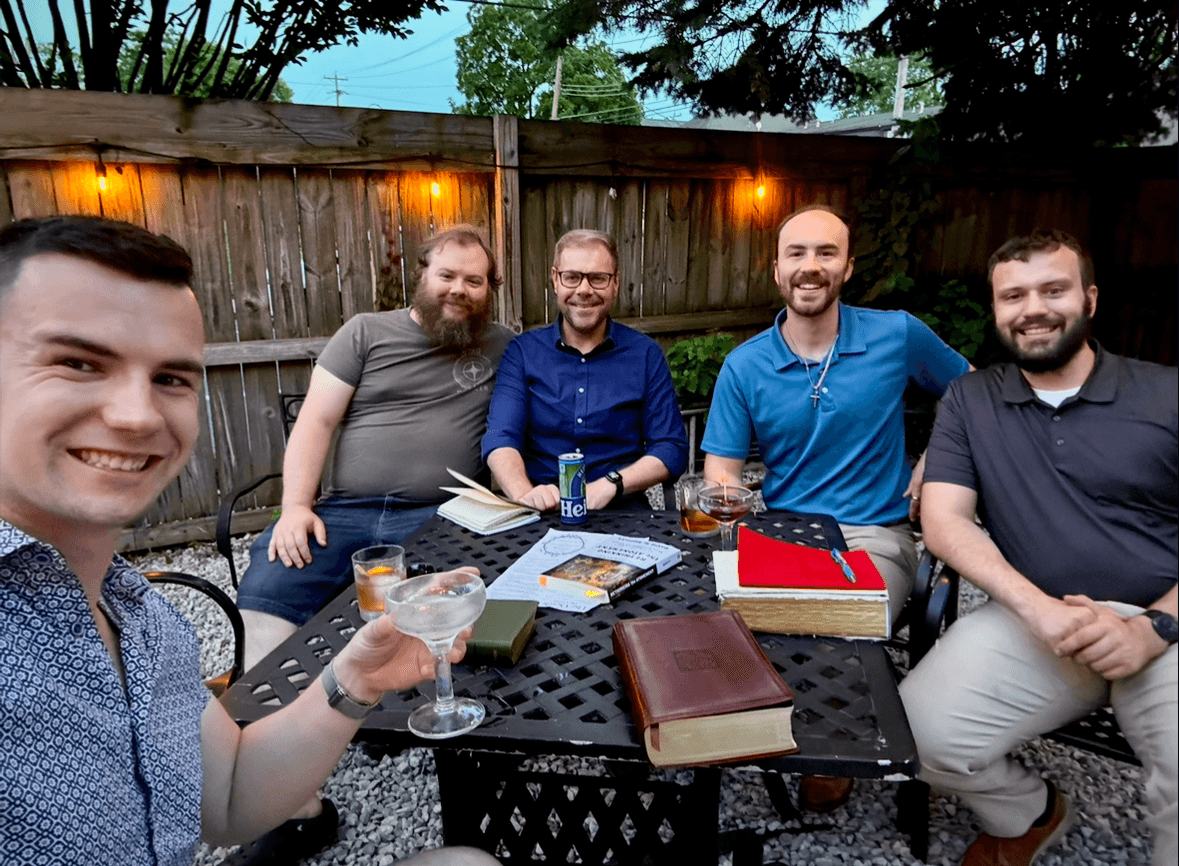 A Scripts and Spirits gathering around an outdoor table with books and drinks.